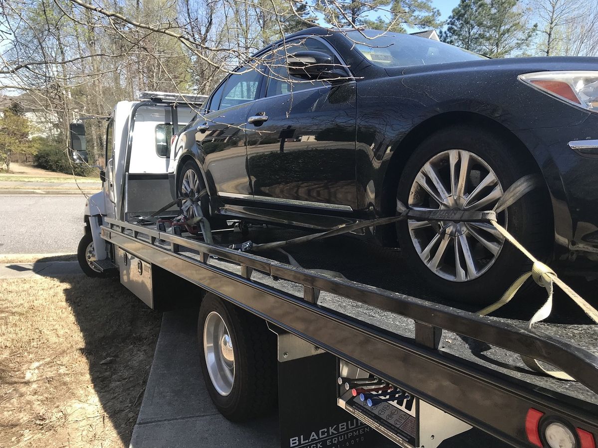 Sedan strapped down on a flatbed tow truck
